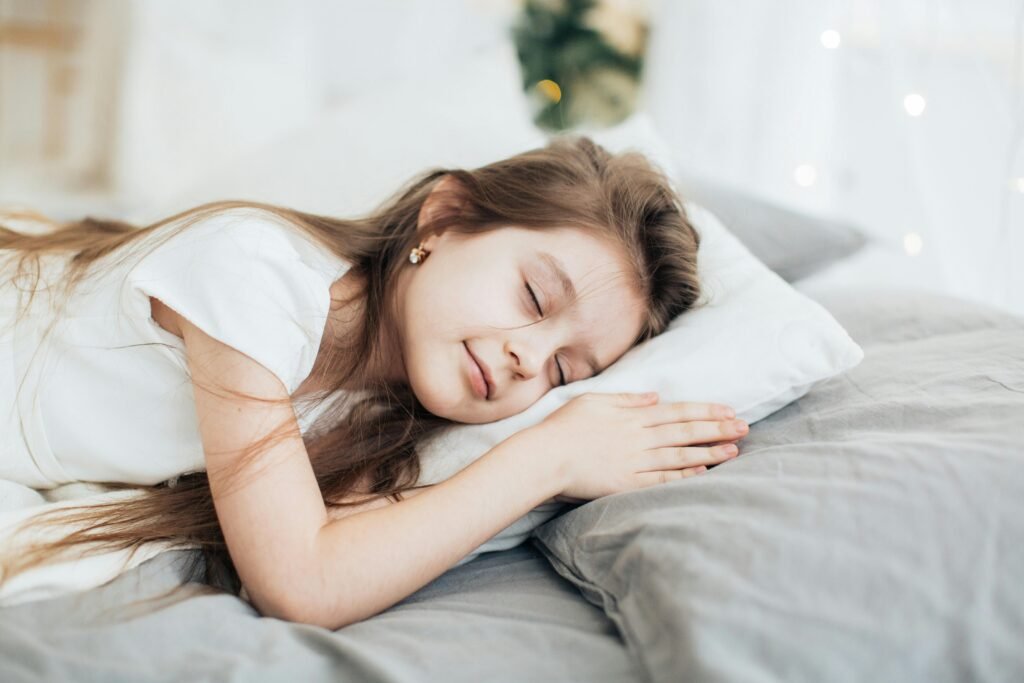 A serene portrait of a young girl peacefully sleeping on a soft pillow indoors.